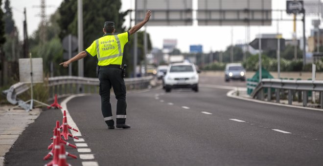 Un agente de la Guardia Civil de Tráfico da el alto a un conductor en un control, con motivo de la campaña puesta en marcha por la DGT sobre control de la tasa de alcohol y presencia de drogas en conductores | EFE