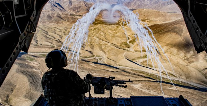 Un soldado del ejército estadounidense sobrevolando Afganistán en helicóptero. / REUTERS