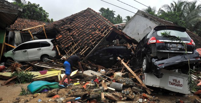 Un hombre trata de rescatar algunos objetos de las ruinas de su casa, arrasada por los efectos del tsunami en Indonesia./REUTERS
