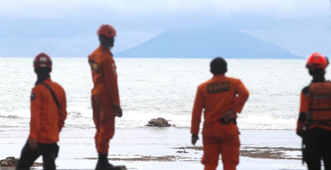Miembros de los servicios de rescate observan el volcán Anak Krakatau desde la playa Carita en Indonesia hoy, 26 de diciembre de 2018. Las autoridades de Indonesia elevaron hoy a 430 los muertos en el tsunami que golpeó el sábado el litoral del estrecho d