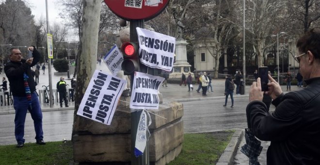 Una señal de tráfico en el centro de Madrid donde se han pegado los carteles de una protesta de pensionistas. AFP/Javier Soriano