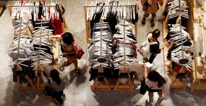 Un grupo de mujeres echan un vistazo a varios conjuntos de ropa en una tienda de un centro comercial de Sidney. REUTERS/Daniel Munoz