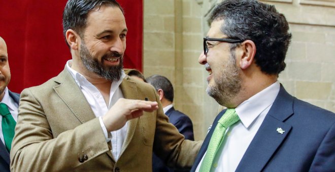 El líder nacional de Vox, Santiago Abascal, y el diputado de esa formación, el juez Francisco Serrano, conversando al inicio de la segunda jornada del debate de investidura del presidente del PP andaluz, Juanma Moreno, en el Parlamento andaluz en Sevilla.