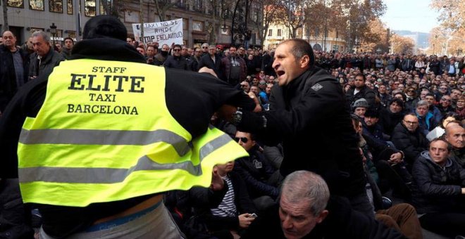 Dos taxistas se encaran durante la asamblea que han celebrado este sábado en Barcelona. (TONI ALBIR | EFE)