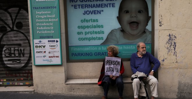 Manifestantes, con un cartel que demanda "Pensión justa, ahora", sentados junto a una clínica en Madrid. REUTERS / Susana Vera