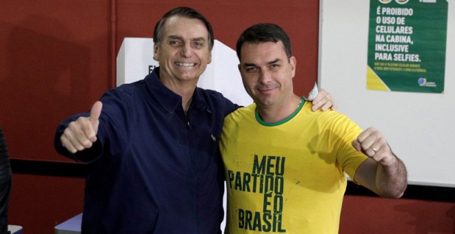 Jair Bolsonaro, y su hijo, Flávio, tras depositar su voto en las elecciones, Río de Janeiro, Brasil, 7 de octubre de 2018. / Ricardo Moraes / Reuters