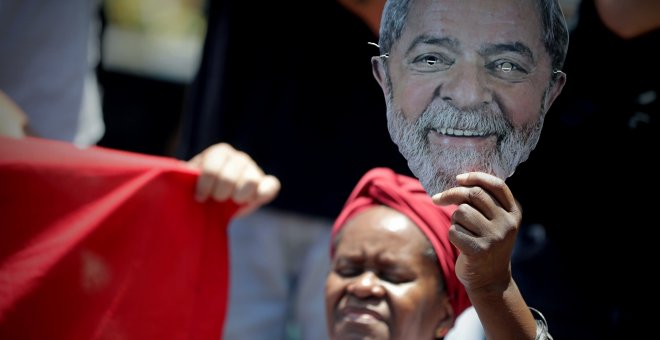 Una mujer sostiene una imagen del expresidente brasileño Luiz Inácio Lula da Silva, durante el entierro de su hermano mayor, Genival Inácio da Silva, conocido como Vavá, en el cementerio de Sao Bernardo do Campo (Brasil). EFE/Fernando Bizerra Jr.