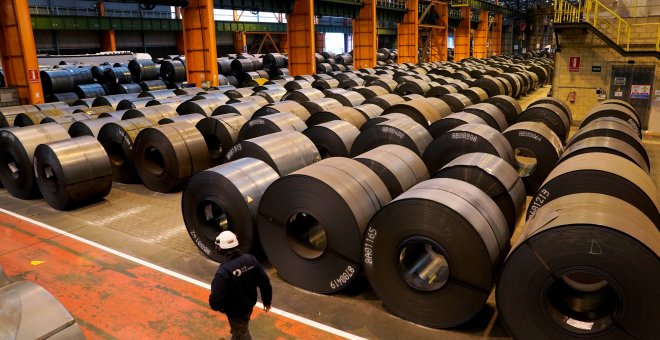 Un trabajador pasa junto a los rollos de acero de la planta de ArcelorMittal en Sestao. REUTERS