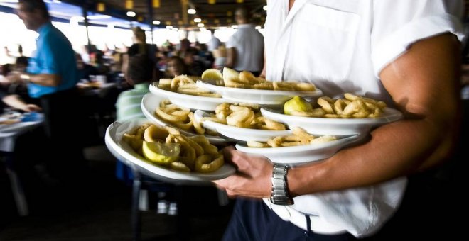 Un camarero con platos de calamares, en una imagen de archivo. / EFE