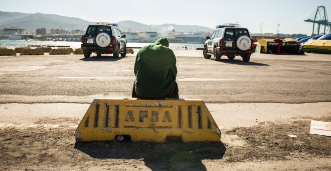 Un migrante descansa en el puerto de Algeciras, custodiado por la Guardia Civil tras ser rescatado por Salvamento Marítimo junto a potros migrantes a bordo de una patera.- JAIRO VARGAS
