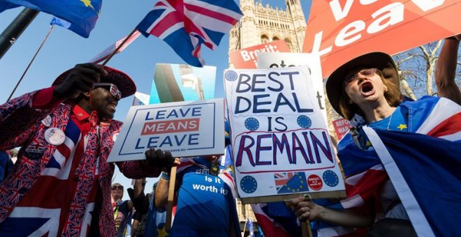 Un hombre a favor del ''brexit'' y una mujer en contra se manifiestan en el exterior del palacio de Westminster, Londres. - EFE