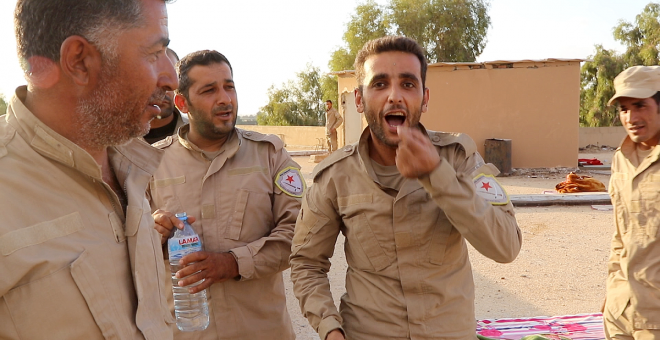 Un miembro de las SDF se burla del DAESH en Raqqa simulando a un yihadista tomando drogas. Foto por Ferran Barber