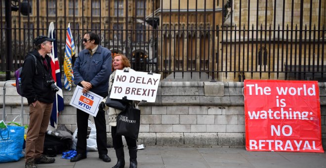 Un manifestante pro-brexit sostiene una pancarta a las puertas del Parlamento en Londres. | Reuters
