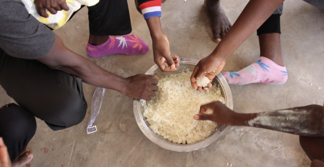 Un grupo de refugiados del campamento libio de Sbaa, compartiendo un cuenco de arroz — MSF