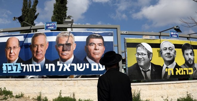 27/03/2019 - Un judío ortodoxo observa los carteles de la campaña electoral israelí. / REUTERS - AMMAR AWAD