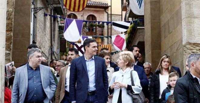 El candidato del PSOE y presidente del Gobierno, Pedro Sánchez, junto a Santos Cerdan (i), y la alcaldesa de Viana Yolanda Gonzalez (d) durante la visita que ha realizado este jueves a la localidad navarra. (JESÚS DIGES | EFE)