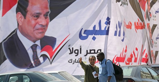 09/04/2019 - Dos hombres frente a un cartel del presidente egipcio Abdel Fattah al-Sisi días antes del referéndum para reformar la Constitución. / REUTERS - MOHAMED ABD EL GHANY