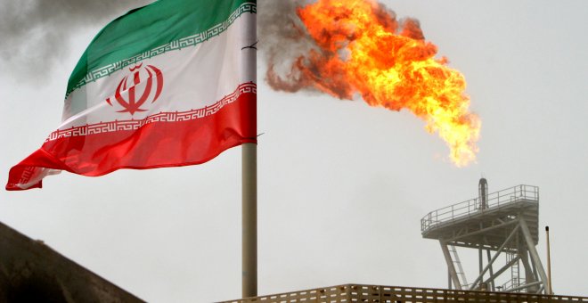 Un bandera de Irán cerca de una llamarada de gas en una plataforma de producción de petróleo en los campos petrolíferos de Soroush, en el Golfo Pérsico. REUTERS / Raheb Homavandi