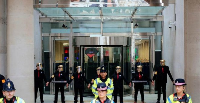 Imagen cedida por el grupo ecologista Extinction Rebellion (XR) que muestra a varios activistas bloqueando la entrada del edificio de la Bolsa de Valores de Londres. (TOM MORTON | EFE)