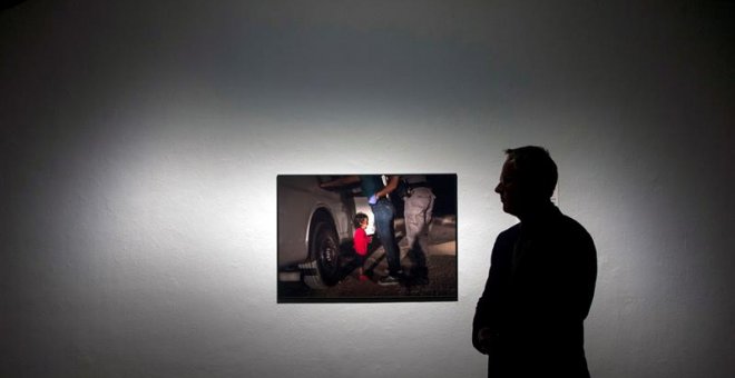 El fotógrafo John Moore, premio World Press Photo 2019, posa junto a su foto '' Crying girl on the Border''. EFE