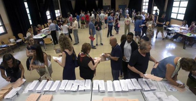Varios ciudadanos eligen las papeletas en un colegio electoral de Barcelona.- EFE