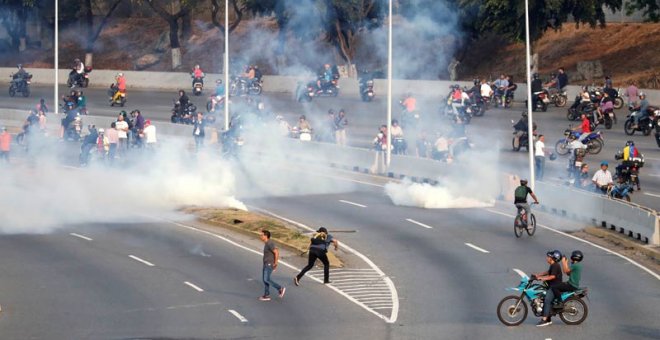 Lanzamiento de gases lacrimógenos en los alrededores de la base militar 'La Carlota' en Caracas. (REUTERS)