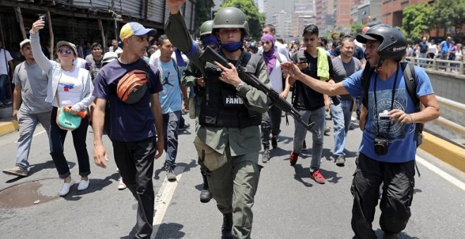 30/04/2019 - Un miembro de la Guardia Nacional de Venezuela tras de unirse a manifestantes antigubernamentales en una marcha, mostrando su apoyo al líder de la oposición Juan Guaidó en Caracas, Venezuela. / REUTERS - Manaure Quintero