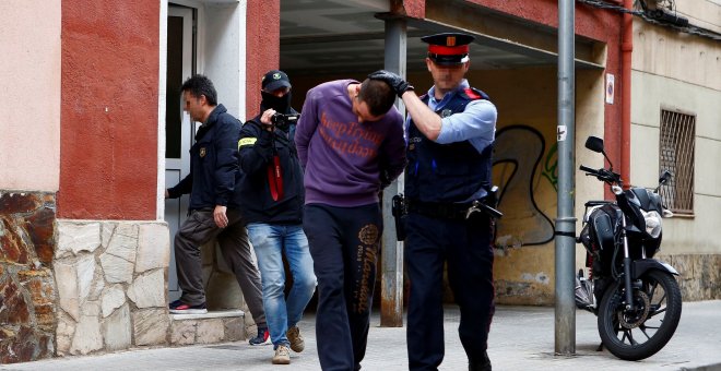 07/05/2019.- Un Mosso d'Esquadra custodia a uno de los dos detenidos en Cornellà de Llobregat (Barcelona) por su supuesta relación con la desaparición de Janet Jumillas. / EFE - ENRIC FONTCUBERTA