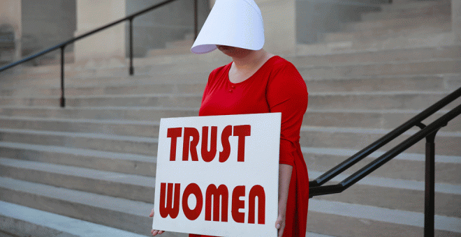 07/05/2019 - Una mujer vestida como sierva sostiene un letrero que dice "Confía en las mujeres" en protesta por el proyecto de ley contra el aborto de Georgia | REUTERS / Elijah Nouvelage