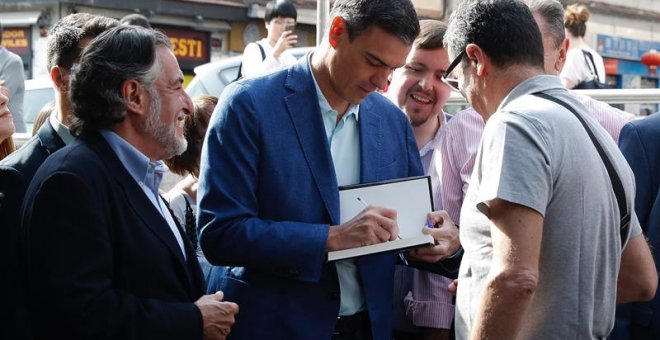 El presidente del Gobierno en funciones y secretario general del PSOE, Pedro Sánchez, saluda a unos simpatizantes durante su visita este miércoles al barrio madrileño de Usera. - EFE