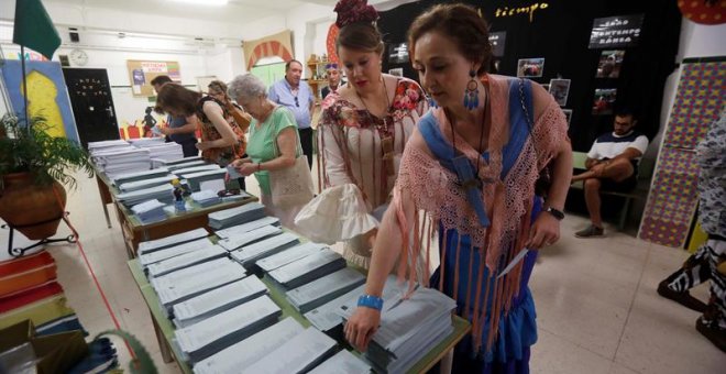 26/05/2019.- Dos mujeres vestidas de flamenca eligen sus papeletas en un colegio de Córdoba donde se está celebrado la Feria de Nuestra Señora de la Salud, hoy 26 de mayo en el que un total de 6,64 millones de electores andaluces podrán ejercer su derecho