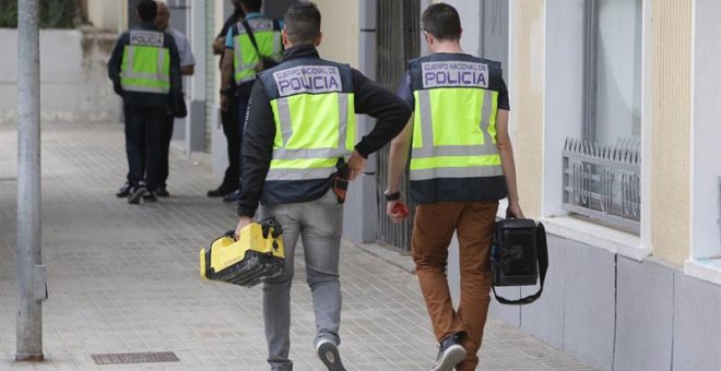 Agentes de la Policía trabajan ante la vivienda de Xàtiva donde la mujer fue asesinada. EFE/Natxo Francés