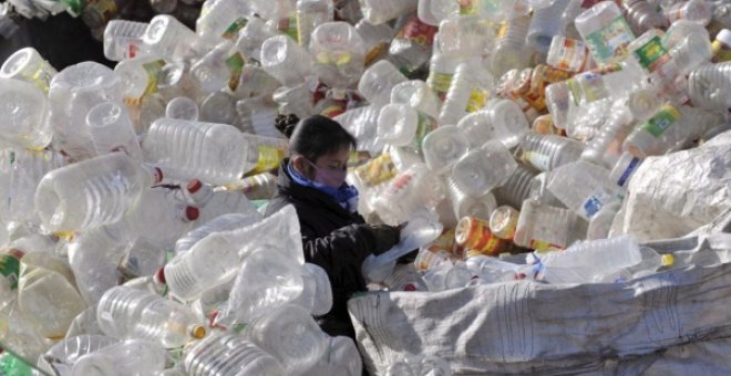 Una trabajadora clasifica recipientes de plástico en un vertedero de China. EFE/Mark