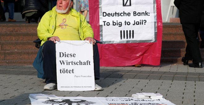 Un manifestante protesta en el exterior de la junta de accionistas de Deutsche Bank, en Fráncfort, con un cartel que dice "Esta economía mata. El Papa Francisco". REUTERS / Kai Pfaffenbach