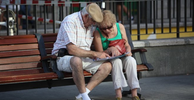 Una pareja de pensionistas, en un banco en la calle.