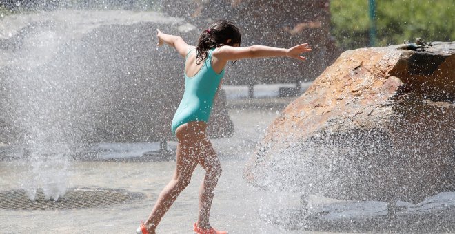 En la imagen, una niña juega en una fuente buscando refrescarse tras las altas temperaturas | EFE