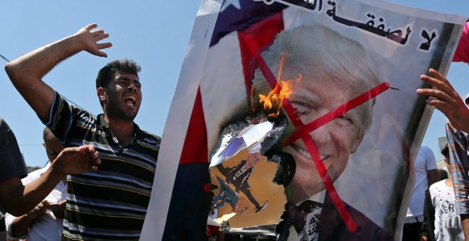 26/06/2019 - Palestinos queman una fotografía del presidente de EEUU, Donald Trump, como protesta contra la cumbre de Bahrein. / REUTERS - IBRAHEEM ABU MUSTAFA