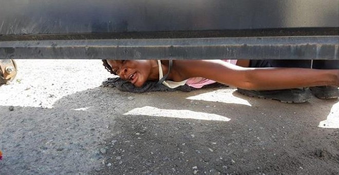 Una mujer haitiana pide ayuda para ella y su hijo desde el interior del albergue Siglo XXI en la ciudad de Tapachula, en el estado de Chiapas (México). - EFE