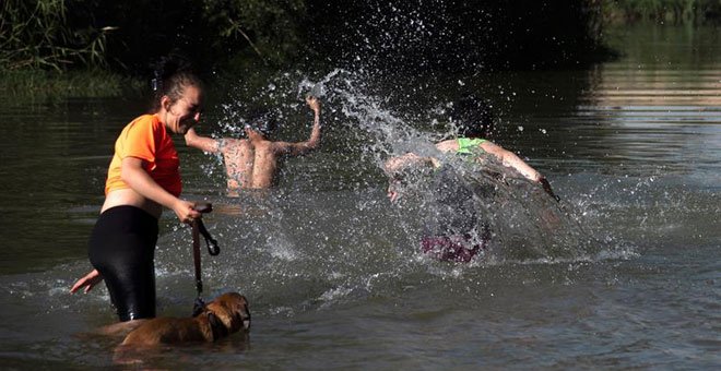 Unos jóvenes se bañan en el río Segre para combatir las altas temperaturas durante la ola de calor. / EFE