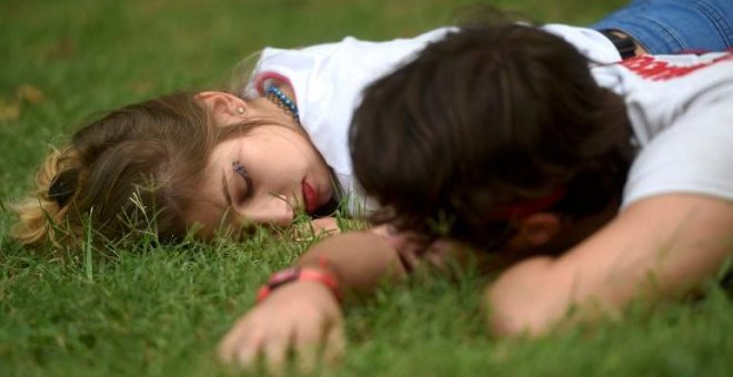 Dos personas durmiendo en el césped. REUTERS/Archivo.