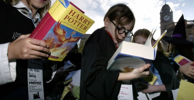 Un grupo de niños leyendo la contraportada del último libro de la saga Harry Potter.