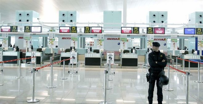 Un mosso de esquadra ante los mostradores de facturación de Iberia, en el aeropuerto de Barcelona-El Prat. EFE/Andreu Dalmau/Archivo