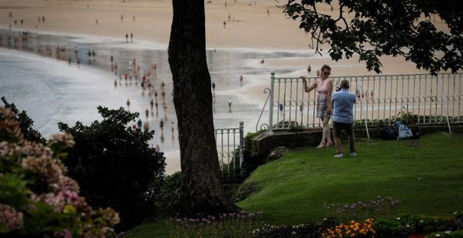 Una pareja se fotografía junto a la playa de La Concha de San Sebastián. (JAVIER ETXEZARRETA | EFE)