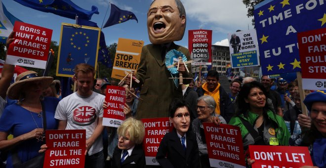 Una persona vestida como el líder del Partido Brexit, Nigel Farage, sostiene títeres que representan a Boris Johnson y Jeremy Hunt durante una marcha anti-Brexit en Londres | Reuters