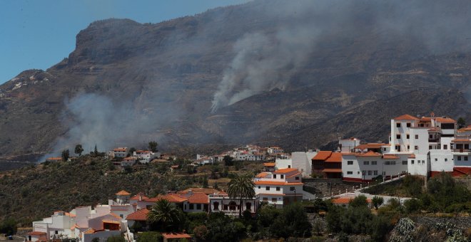 11/08/2019.- Vista del pueblo de Tejeda y detrás uno de los focos del incendio que arrasa este domingo los municipios de Tejeda, Artenara y Gáldar, en Gran Canaria. EFE/Elvira Urquijo A.