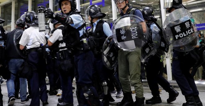 La policía antidisturbios usa spray de pimienta para dispersar a los manifestantes contra el proyecto de ley de extradición durante una manifestación masiva después de que una mujer recibió un disparo en el ojo, en el aeropuerto internacional de Hong Kong