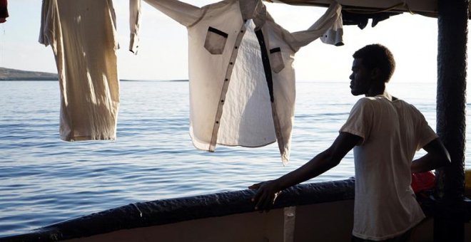 Un migrante mira este domingo desde la cubierta de el buque Open Arms las costas de Lampedusa (Italia). - EFE