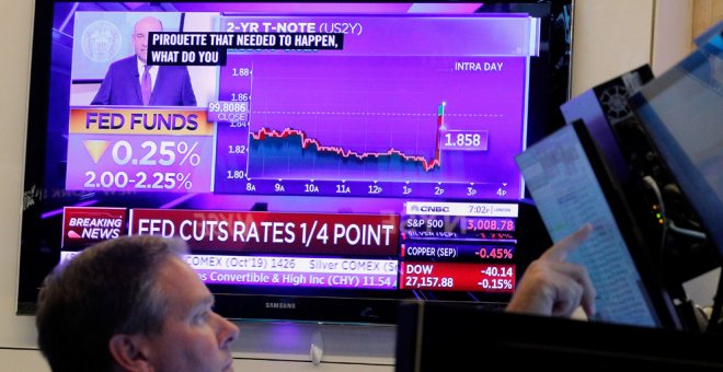 Un operador de la Bolsa de Nueva York (NYSE, en sus siglas en inglés) observa en un monitor el anuncio de la última bajada de tipos de la Reserva Federal de EEUU. REUTERS / Brendan McDermid