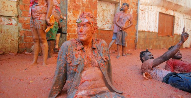 28/08/2019 - Un hombre se sienta en la acera tras la Tomatina celebrada en el pueblo Bunyol, donde un año más es el escenario de la batalla hortofrutícola más colorada del mundo. REUTERS/Heino Kali