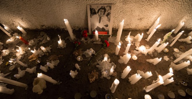 Detalle de una fotografía de uno de los detenidos desaparecidos durante la dictadura chilena (1973-1990) rodeado de velas en el Estadio Nacional de Chile, durante uno de los actos de conmemoración por el 46º aniversario del golpe de Estado que acabó con l